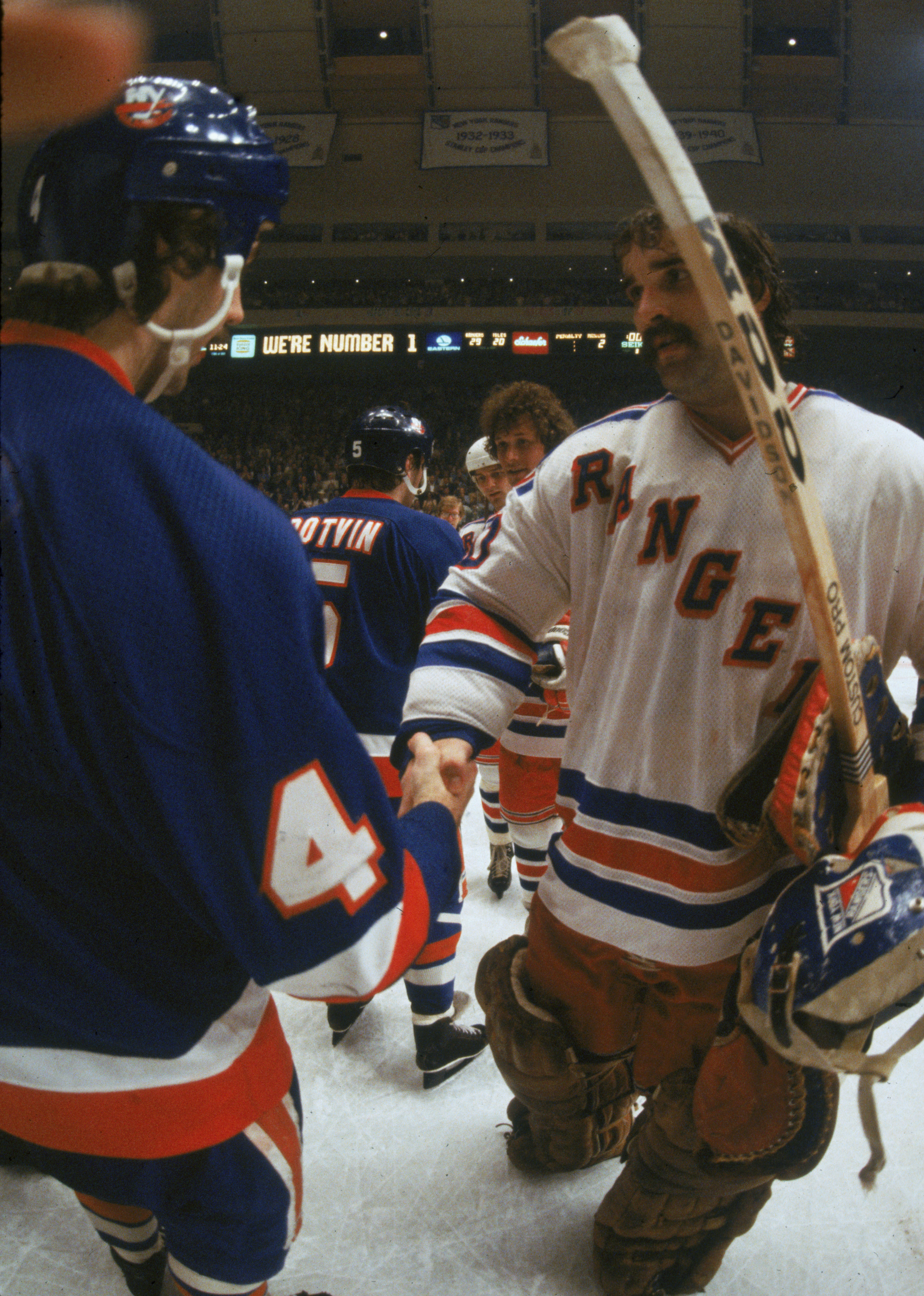 Canadian hockey player John Davidson (right), goalkeeper for the New York Rangers, shakes hands with Bob Lorimer (left) of the New York Islanders following a playoff game at Madison Square Garden, New York, New York, 1979. Also visible are Islander Denis Potvin (#5) who shakes with Ranger Ron Duguay, and Ranger Ron Greschner (behind Duguay). (Photo by Melchior DiGiacomo/Getty Images)
